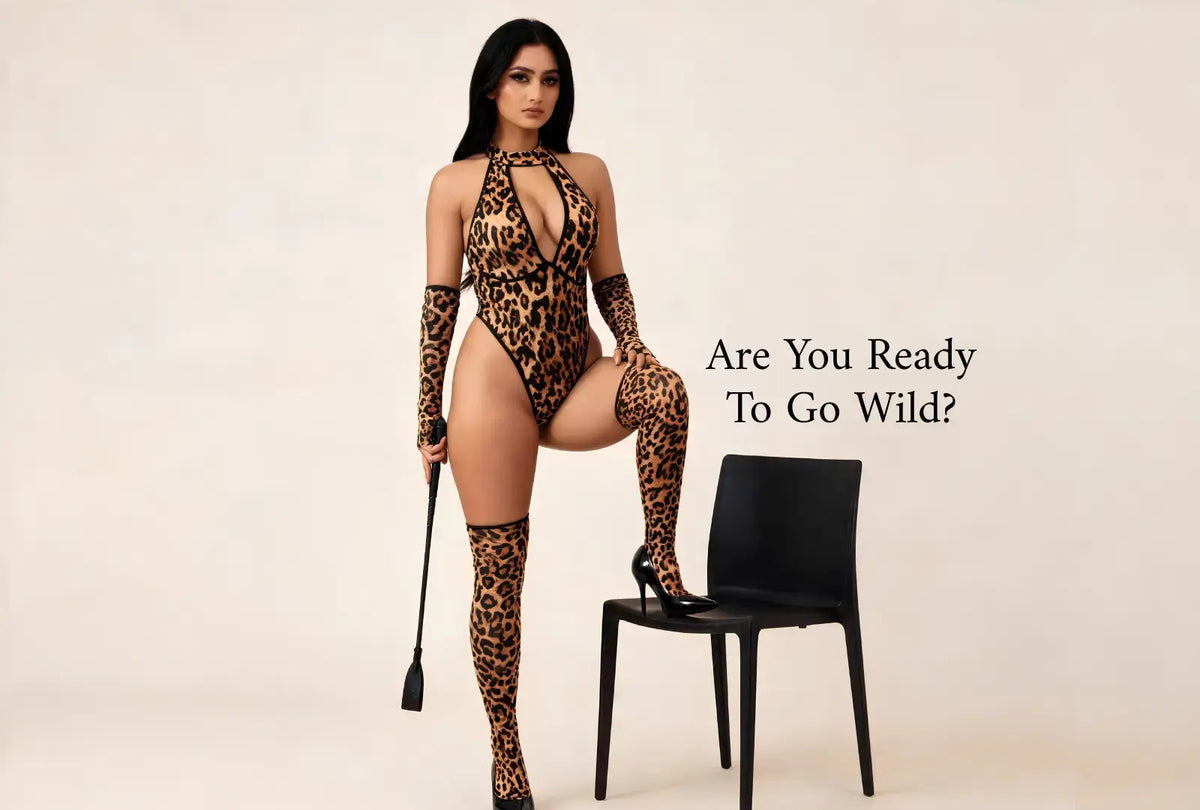 A woman poses in a leopard-print bodysuit with matching thigh-high stockings, holding a riding crop next to a black chair, against a plain beige background with the text 'Are You Ready To Go Wild?' on the right.