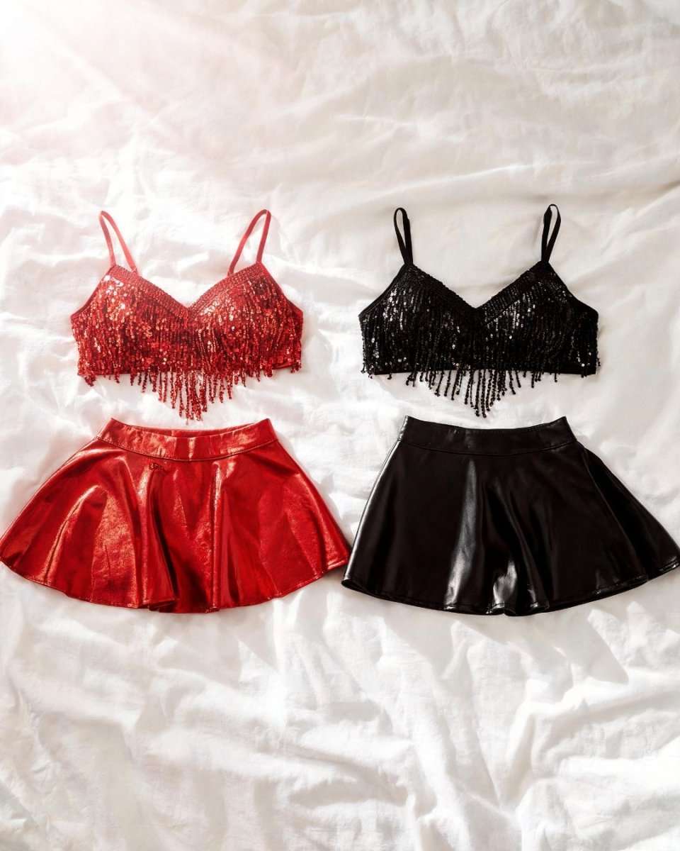 Two two-piece outfit sets laid flat on a white wrinkled fabric background. The left set is red, featuring a red sequined fringe crop top and a shiny red mini skirt.