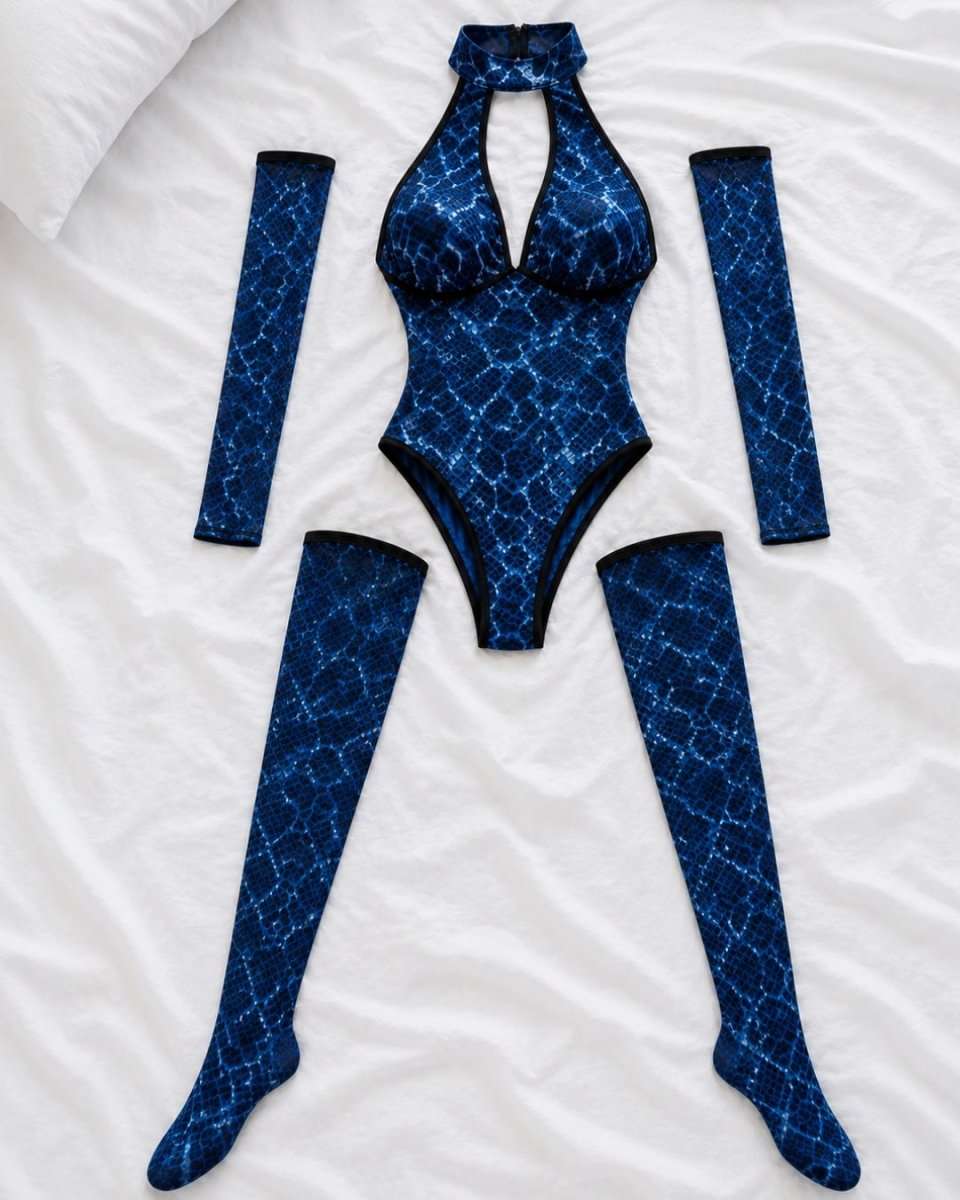 A blue and black snakeskin-patterned one-piece bodysuit with matching thigh-high socks and arm warmers, laid flat on a white bed.