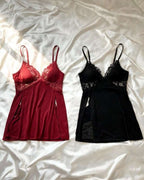 Two lace-trimmed camisole-style nightgowns laid flat on white satin fabric: one red and one black.