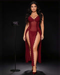 A woman modeling a sheer burgundy lace babydoll lingerie chemise with a high leg slit and long draped train, standing against a dark studio background.