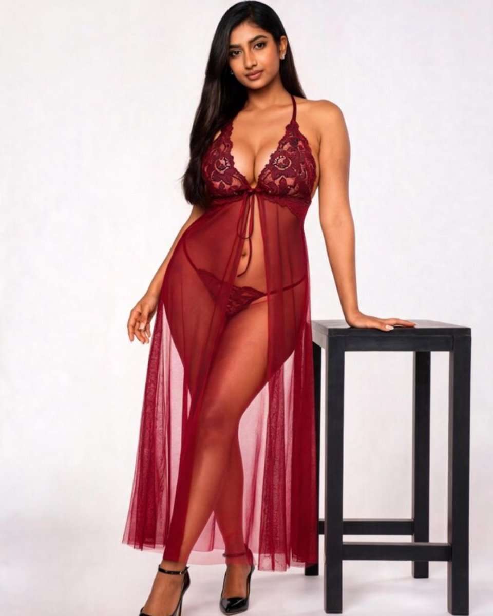 A woman models a sheer burgundy lace babydoll lingerie chemise with matching underwear, standing next to a black stool against a white studio background.